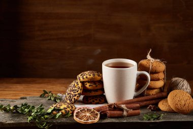 Geleneksel Noel çay bir fincan sıcak çay, kurabiye ve süslemeleri üzerinde ahşap bir masa, seçici odak konseptiyle