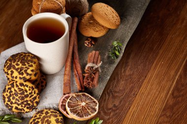 Geleneksel Noel çay bir fincan sıcak çay, kurabiye ve süslemeleri üzerinde ahşap bir masa, seçici odak konseptiyle