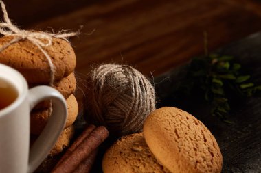 Bir fincan sıcak çay, kurabiye ve dekorasyon ahşap arka plan, seçici odak üzerinde bir oturum ile Noel kavramı