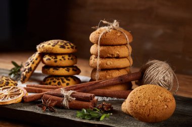 Tanımlama bilgileri, tarçın ve ahşap arka plan üzerinde kurutulmuş portakal yığını ile Noel kompozisyon yakın çekim.