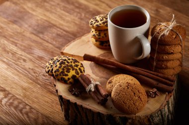 Bir fincan sıcak çay, kurabiye ve dekorasyon ahşap arka plan, seçici odak üzerinde bir oturum ile Noel kavramı