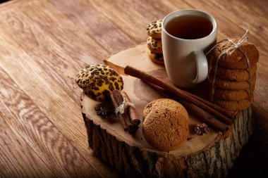 Bir fincan sıcak çay, kurabiye ve dekorasyon ahşap arka plan, seçici odak üzerinde bir oturum ile Noel kavramı