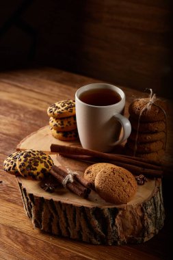 Bir fincan sıcak çay, kurabiye ve dekorasyon ahşap arka plan, seçici odak üzerinde bir oturum ile Noel kavramı