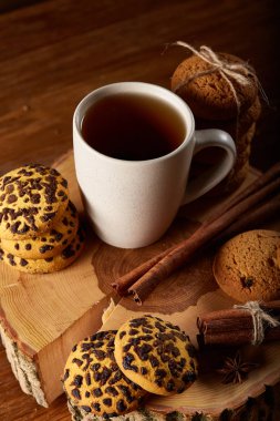 Bir fincan sıcak çay, kurabiye ve dekorasyon ahşap arka plan, seçici odak üzerinde bir oturum ile Noel kavramı