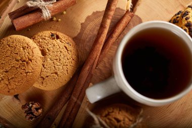 Bir fincan sıcak çay, kurabiye ve dekorasyon ahşap arka plan, seçici odak üzerinde bir oturum ile Noel kavramı