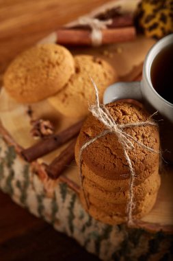 Bir fincan sıcak çay, kurabiye ve dekorasyon ahşap arka plan, seçici odak üzerinde bir oturum ile Noel kavramı