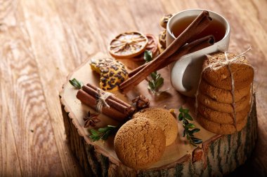 Bir fincan sıcak çay, kurabiye ve dekorasyon ahşap arka plan, seçici odak üzerinde bir oturum ile Noel kavramı