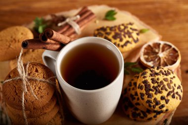 Bir fincan sıcak çay, kurabiye ve dekorasyon ahşap arka plan, seçici odak üzerinde bir oturum ile Noel kavramı