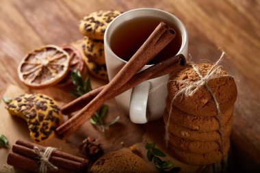 Bir fincan sıcak çay, kurabiye ve dekorasyon ahşap arka plan, seçici odak üzerinde bir oturum ile Noel kavramı