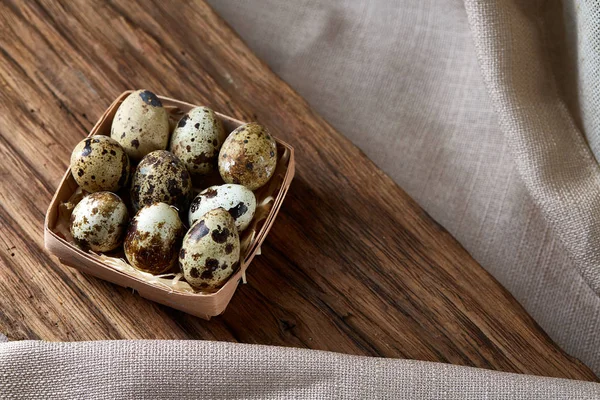 Huevos de codorniz en una caja sobre un fondo rústico de madera, vista superior, enfoque selectivo . — Foto de Stock