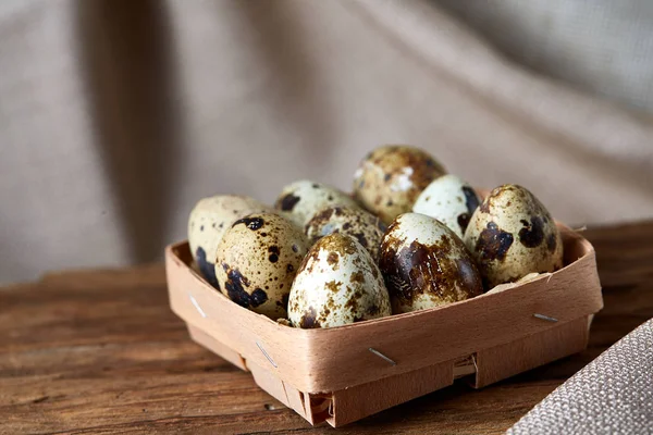 Quail eggs in a box on a rustic wooden background, top view, selective focus. — Stock Photo, Image