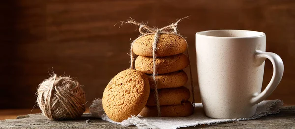 Conceito tradicional de chá de Natal com uma xícara de chá quente, biscoitos e decorações em uma mesa de madeira, foco seletivo — Fotografia de Stock