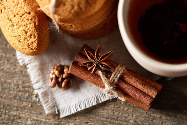 Concepto tradicional de té de Navidad con una taza de té caliente, galletas y decoraciones en una mesa de madera, enfoque selectivo —  Fotos de Stock