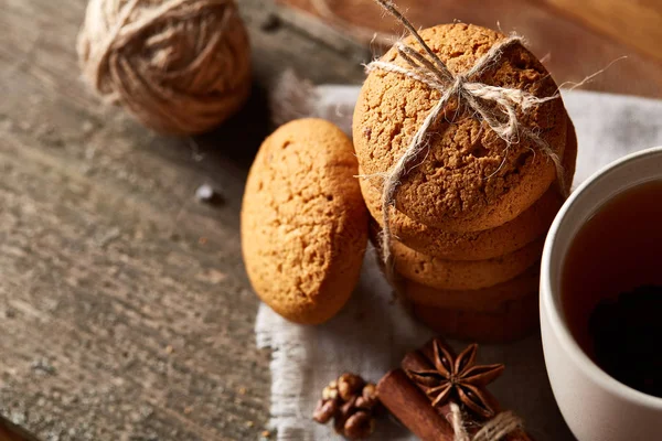 Conceito tradicional de chá de Natal com uma xícara de chá quente, biscoitos e decorações em uma mesa de madeira, foco seletivo — Fotografia de Stock