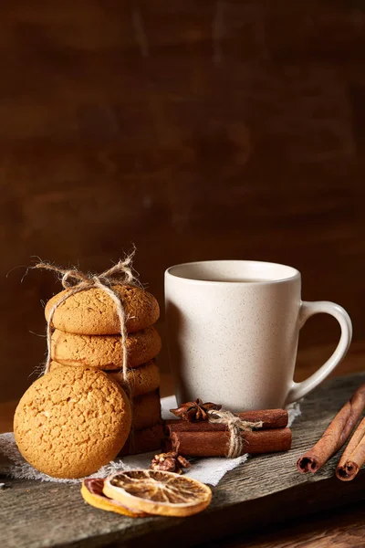 Tradizionale concetto di tè natalizio con una tazza di tè caldo, biscotti e decorazioni su un tavolo di legno, focus selettivo — Foto Stock