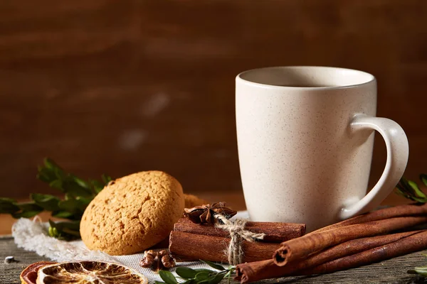 Concepto tradicional de té de Navidad con una taza de té caliente, galletas y decoraciones en una mesa de madera, enfoque selectivo —  Fotos de Stock