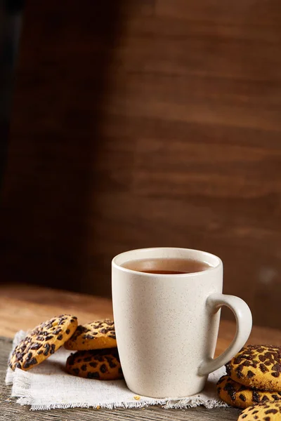 Copa de galletas fritas de té y chocolate en servilleta blanca hecha en casa en estilo país, enfoque selectivo . —  Fotos de Stock