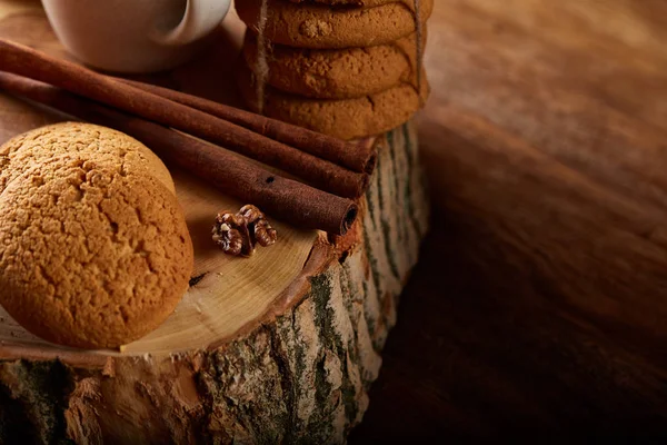 Concepto de Navidad con una taza de té caliente, galletas y decoraciones en un registro sobre fondo de madera, enfoque selectivo —  Fotos de Stock