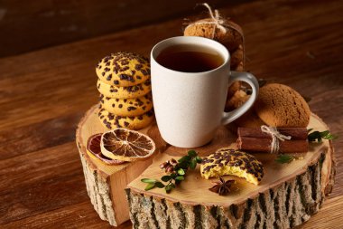 Bir fincan sıcak çay, kurabiye ve dekorasyon ahşap arka plan, seçici odak üzerinde bir oturum ile Noel kavramı