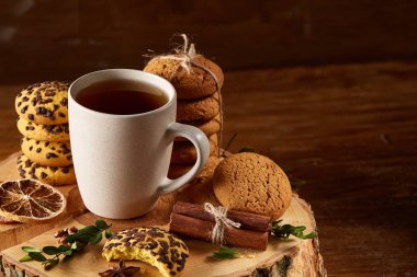 Bir fincan sıcak çay, kurabiye ve dekorasyon ahşap arka plan, seçici odak üzerinde bir oturum ile Noel kavramı