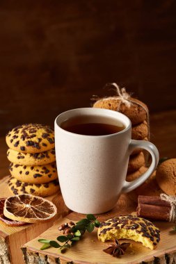 Bir fincan sıcak çay, kurabiye ve dekorasyon ahşap arka plan, seçici odak üzerinde bir oturum ile Noel kavramı