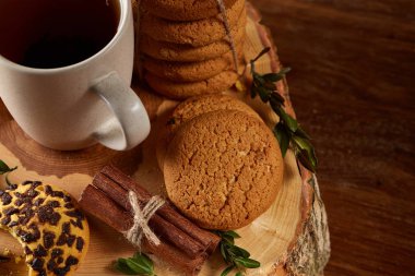 Bir fincan sıcak çay, kurabiye ve dekorasyon ahşap arka plan, seçici odak üzerinde bir oturum ile Noel kavramı