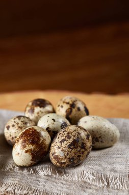 Bir günlük bir peçeteye yuvarlağına düzenlenmiş ahşap arka plan, yakın çekim, seçici odak bıldırcın yumurtası.