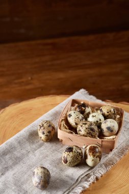 Yumurtalar bıldırcın kutusunun kompozisyon yumurta bir günlük saf bir peçeteye üzerinde ahşap arka plan üzerinde Üstten Görünüm