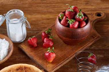 Çilekli pasta, pasta kesme tahtası üzerinde ahşap arka plan üzerinde seçici odak yemek pişirmek için çilek tarifi