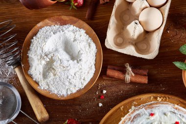 Top çilekli pasta ya da kek üzerine ahşap masa, düz yatıyordu yemek pişirmek için ham maddeler görüntüleyin. Fırın arka plan.