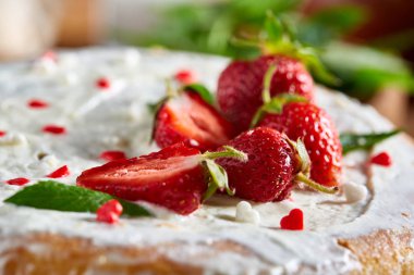 Çilek ve rustik ahşap zemin, seçici odak üzerine nane yaprakları ile süslenmiş krem şanti ile tart