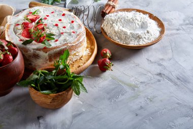 Çilekli tart beyaz arka plan üzerinde düz yatıyordu organik maddeler tarafından çevrili ekşi krem şanti ile kaplı.