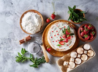 Çilekli tart beyaz arka plan üzerinde düz yatıyordu organik maddeler tarafından çevrili ekşi krem şanti ile kaplı.