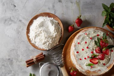 Çilekli tart beyaz arka plan üzerinde düz yatıyordu organik maddeler tarafından çevrili ekşi krem şanti ile kaplı.