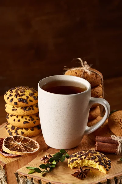 Bir fincan sıcak çay, kurabiye ve dekorasyon ahşap arka plan, seçici odak üzerinde bir oturum ile Noel kavramı