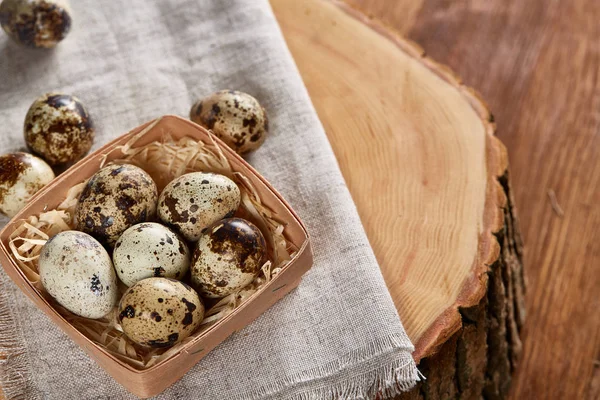 Yumurtalar bıldırcın kutusunun kompozisyon yumurta bir günlük saf bir peçeteye üzerinde ahşap arka plan üzerinde Üstten Görünüm