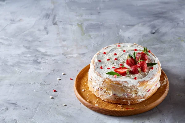 Taart met aardbeien en slagroom versierd met muntblaadjes op wit gestructureerde achtergrond, selectieve aandacht — Stockfoto