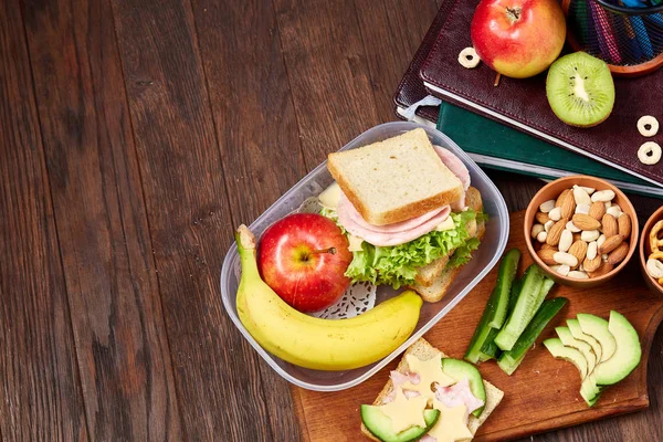 Concept van school lunchpauze met gezonde lunch box en school supplies op houten bureau, selectieve aandacht. — Stockfoto