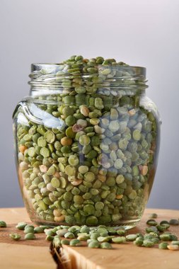 Cam üzerinde gri bir oturum ham yeşil bezelye bulanık arka plan, yakın çekim, seçici odak.