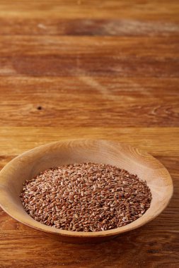 Ahşap arka plan, üstten görünüm, yakın çekim bir tabak içinde keten tohumu.