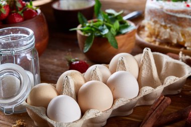 Top çilekli pasta ya da kek üzerine ahşap masa, düz yatıyordu yemek pişirmek için ham maddeler görüntüleyin. Fırın arka plan.