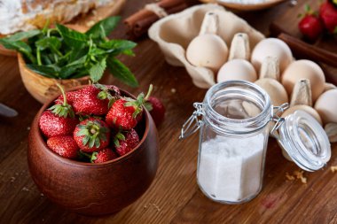 Top çilekli pasta ya da kek üzerine ahşap masa, düz yatıyordu yemek pişirmek için ham maddeler görüntüleyin. Fırın arka plan.