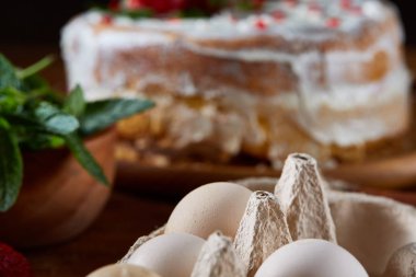 Çilekli pasta ya da kek üzerine ahşap masa, sığ derinlik-in tarla yemek pişirmek için ham maddeler. Fırın arka plan.