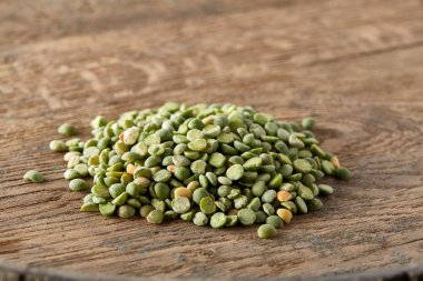 Antika ahşap arka plan, yakın çekim, en iyi görünüm, seçici odak yeşil bezelye yığını.