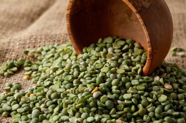 Çuval bezi masa örtüsü, yakın çekim, en iyi görünüm, seçici odak, sığ derinlik-in tarla yeşil bezelye ile devrilmiş bir kase.