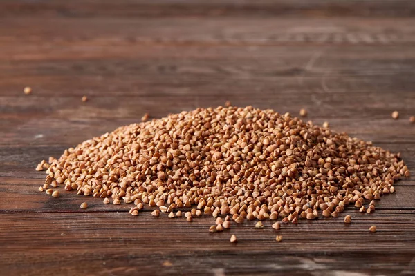 Karabuğday kabuğu çıkarılmış tane ahşap arka plan, üstten görünüm, yakın çekim, seçici odak, sığ derinlik-in tarla yığını