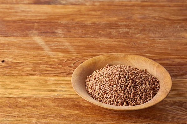 Bir yuvarlak ahşap plaka rustik ahşap arka plan, üstten görünüm, seçici odak yakın çekim buğday.