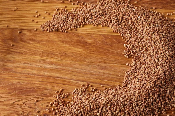 Karabuğday kabuğu çıkarılmış tane yarım daire ahşap arka plan, üstten görünüm, yakın çekim, seçici odak düzenlenen.