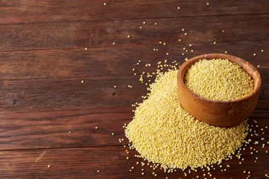 Darı rustik ahşap arka plan, üstten görünüm, yakın çekim, seçici odak bir ahşap kase.