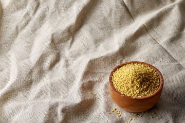 Darı saf masa örtüsü, üstten görünüm, yakın çekim, seçici odak bir ahşap kase.